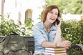 Laughing Female Student Outside Using Cell Phone Sitting on Bench Royalty Free Stock Photo