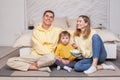 Laughing friendly family, cute parents with child boy son sitting by the bed and eating popcorn Royalty Free Stock Photo