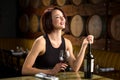 Laughing fun dating woman date night glass of wine at winery with barrels in background