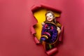 Laughing funny child girl in a witch costume of halloween looking, smiling and scares through a hole of red, yellow Royalty Free Stock Photo