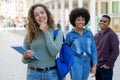 Laughing german female student with backpack and group of international students Royalty Free Stock Photo