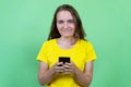 Laughing german young adult woman with brunette hair sending message with mobile phone Royalty Free Stock Photo