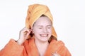 Laughing girl cleaning ears with cotton swab. Portrait teenage in towel on head