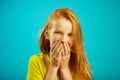 Laughing girl covered her mouth with hands, holding back laughter, expresses sincere emotions of joy, has a cheerful Royalty Free Stock Photo