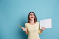 Laughing girl holding notebook over blue background Royalty Free Stock Photo