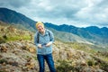 Laughing girl with a mobile in her hand against the backdrop of the mountain landscape. Happy woman traveler in the Altai Royalty Free Stock Photo