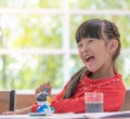 Laughing girl painting a doll in Art classroom, for creativit