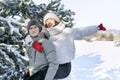 Laughing girl riding on the back of a guy. Lovers having fun in the winter forest Royalty Free Stock Photo