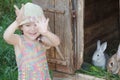 Laughing girl showing hands in front of farm hutch with domestic rabbits Royalty Free Stock Photo