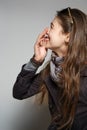 Laughing girl standing in profile and covering mouth with hand Royalty Free Stock Photo