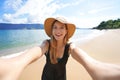 Laughing girl takes self portrait on empty tropical island in her summer vacation. Selfie of smiling tourist woman on Ilhabela Royalty Free Stock Photo