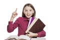 Laughing girl teenager in glasses sits at a table with books. Knowledge and education. Isolated on a white background