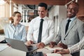 Diverse businesspeople laughing while working at an office table Royalty Free Stock Photo