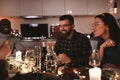 Laughing group of diverse friends enjoying a candlelit dinner party Royalty Free Stock Photo