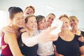 Laughing group of friends taking selfies in a dance class