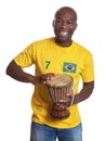 Laughing guy from Brazil with drum supporting his team