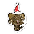 laughing hand drawn distressed sticker cartoon of a dog wearing santa hat