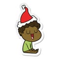 laughing hand drawn sticker cartoon of a man wearing santa hat