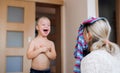 A laughing handicapped down syndrome boy with his mother indoors having fun.