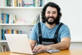 Laughing handyman with beard working at computer Royalty Free Stock Photo