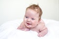 Laughing and happy baby boy drooling or burping laying on white background Royalty Free Stock Photo