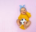 Happy baby girl lay in bed with soccer ball toy Royalty Free Stock Photo