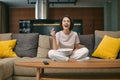 Laughing happy pretty young girl watching sitcom movie or stand up comedy, sitting on sofa with popcorn, rest at home Royalty Free Stock Photo