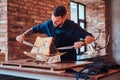 Laughing hef cook pierces with knives exclusive jerky meat in kitchen with loft interior. Royalty Free Stock Photo