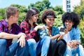 Laughing hispanic and african american hipster young adult people with phone Royalty Free Stock Photo