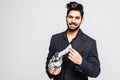 Laughing Indian business man holding a handful of money and put in pot isolated over white Royalty Free Stock Photo