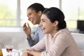 Laughing Indian woman enjoy pastime in cafe with best friends