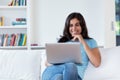 Laughing indian woman in quarantine at computer