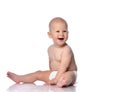 Laughing infant child baby boy toddler in diaper is sitting  looking aside at free copy space on white Royalty Free Stock Photo