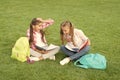 Laughing from joke. having fun on green grass. two little kids with backpack. small girl play and study on school break Royalty Free Stock Photo