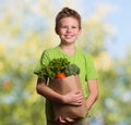 Laughing kid holding paper shopping bag full of fresh organic fr Royalty Free Stock Photo