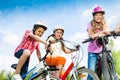 Laughing kids in helmets hold bike handle-bars Royalty Free Stock Photo