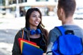 Laughing latin american female student talking with male student in city Royalty Free Stock Photo