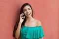 Laughing latin american young adult woman with long dark hair talking with boyfriend at mobile phone Royalty Free Stock Photo