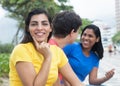Laughing latin woman in a yellow shirt with friends Royalty Free Stock Photo