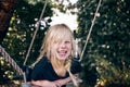 Laughing little girl playing on a tree swing outdoors Royalty Free Stock Photo