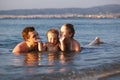 Laughing little boy with his parents at the sea