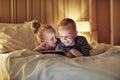 Laughing little brother and sister watching videos before bedtim Royalty Free Stock Photo