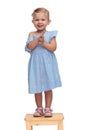 Laughing little girl in blue dress is clapping her hands Royalty Free Stock Photo