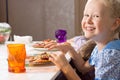 Laughing little girl eating homemade pizza