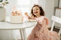 A laughing little girl eats a birthday cake on her birthday at home Royalty Free Stock Photo