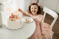 A laughing little girl eats a birthday cake on her birthday at home Royalty Free Stock Photo