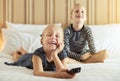 Laughing little girl and her brother watching television at home