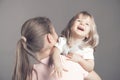 Laughing little girl looks happy in mother`s arms. Beautiful baby girl in the arms of a young mom. Woman holding her Royalty Free Stock Photo