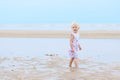 Laughing little girl plays on the beach Royalty Free Stock Photo