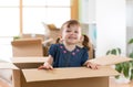 Laughing little girl sitting inside cardboard boxe in her new home Royalty Free Stock Photo